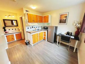 a small kitchen with a refrigerator and a table at Rivermount Motel in Little Fort