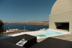 a villa with a swimming pool with a view of the water at Black Diamond Suites in Akrotiri