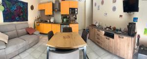 a kitchen and a living room with a couch and a table at Chez Caro in Chaveignes