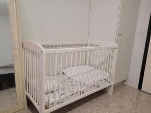a white crib in a room with a mirror at Private Room in Shared Apartment in Vaasa +11 photos