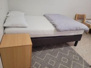a bedroom with a bed and a wooden table at Private Room in Shared Apartment in Vaasa