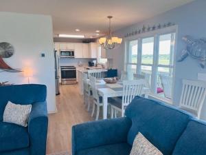 a living room with a blue couch and a table with chairs at Libby's Lookout in Holden Beach