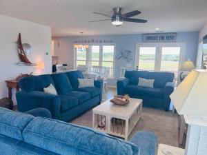 a living room with blue couches and a table at Libby's Lookout in Holden Beach +45 photos