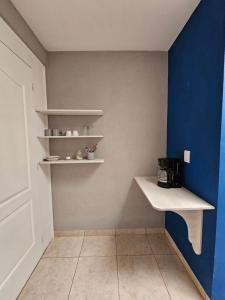 a kitchen with a blue and white wall and shelves at Sensity Home Habitación 5 A Cómoda y calida con baño compartido in Tehuacán