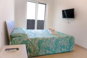 a small room with a bed and a television at Casa Vacanze Beira Mar - Fiumicino in Fiumicino