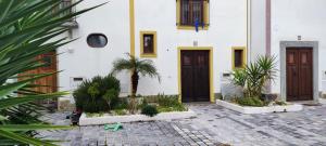 a building with two doors and a courtyard with plants at Casa próxima da praia fluvial in Mourão