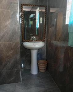 a bathroom with a sink and a mirror at Capricorn by Quest-Cape Maclear in Monkey Bay