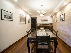 
a room with a table, chairs, and a painting on the wall at O Veleiro Bed and Breakfast in Rio de Janeiro
