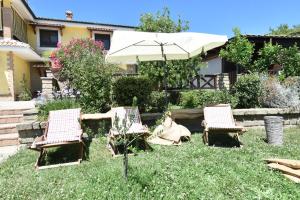 two chairs and an umbrella in a yard at Casa del Sole in Sasso +5 photos