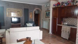 a living room with a white couch and a tv at Casa del Sole in Sasso