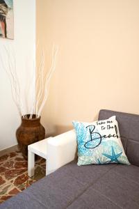 a couch with a pillow that says take me to the beach at Casa Donna Celestina in Letojanni +19 photos