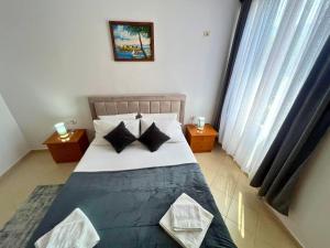 - une chambre avec un grand lit et des oreillers noirs et blancs dans l'établissement Deir Apartment, à Berat