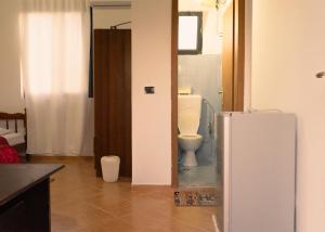 a bathroom with a toilet and a white refrigerator at Morina Rooms in Durrës