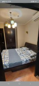 a bedroom with a bed and a chandelier at Porto marina luxury flat for families onlyشاليه فاخرداخل بورتو مارينا in El Alamein +76 photos