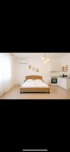 a white bedroom with a bed and a kitchen at Marina studio in Mamaia Nord