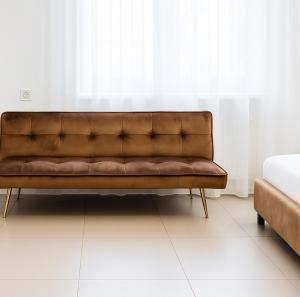 a brown couch in a room with a window at Marina studio in Mamaia Nord