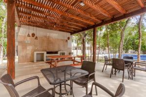 a patio with a table and chairs and a fireplace at RayoDeSol Condo10min to Beach,Gym,Pool,WIFI 200MB in Playa del Carmen