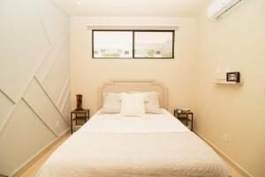 a bedroom with a bed with white sheets and a window at RayoDeSol Condo10min to Beach,Gym,Pool,WIFI 200MB in Playa del Carmen +36 photos