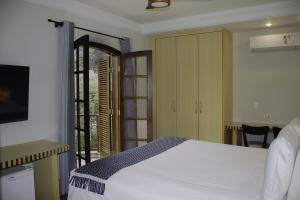 Un dormitorio con una cama y una puerta corrediza de vidrio. en Pousada Big Bear, en Campos do Jordão