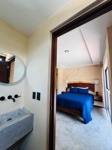Un dormitorio con una cama azul y un espejo. en Kauil Tulum, en Tulum 4 fotos más