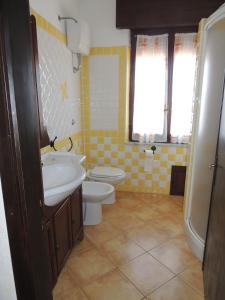 a bathroom with a sink and a toilet and a window at Appartamento Mariolu 3 in Santa Maria Navarrese