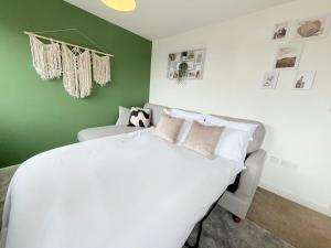a bedroom with a white bed and a green wall at Penthouse with City Views in Bristol +7 photos