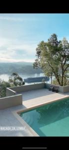 a swimming pool with a view of the water at A casa da Lomba in Lomba