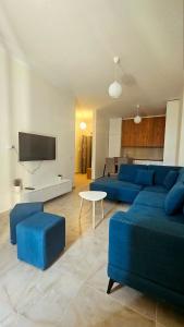 a living room with blue couches and a tv at Near the beach, Blue Mirage Apartment in Orikum