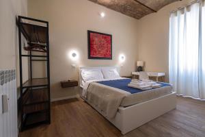 a bedroom with a bed with a blue comforter at The Heartbeat of Bohemian Rome in Rome