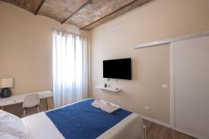 a bedroom with a bed and a tv on the wall at The Heartbeat of Bohemian Rome in Rome