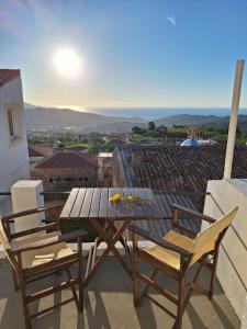 a table and chairs on a balcony with a view at balconi 1911 - Traditional house in Ydroussa, Samos in Ydroússa