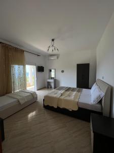 a large bedroom with two beds and a window at Vila Alexandros in Qeparo