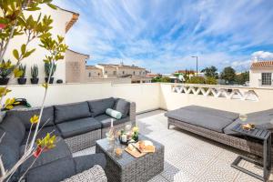 a patio with couches and a table on a roof at Beautiful townhouse in downtown Ferragudo in Ferragudo