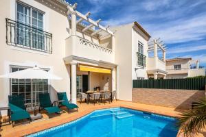 a villa with a swimming pool and a house at Beautiful townhouse in downtown Ferragudo in Ferragudo