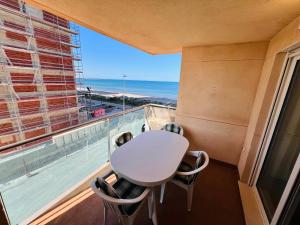 a table and chairs in a balcony with a view of the ocean at Residencia Dos Mares I, Bloque 3, Escalera 1, 2º C in La Manga del Mar Menor