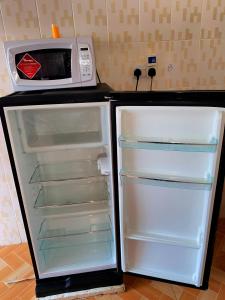 a refrigerator with its door open next to a microwave at Lakeside Two Bedroom Penthouses in Goat Island