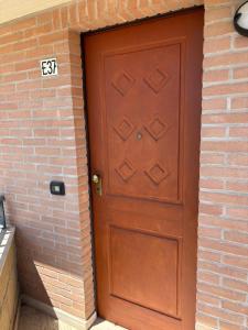 een bruine deur in een bakstenen muur met een bordje erop bij Residence IL BORGO 37 in Tortoreto Lido