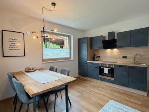 a kitchen with a wooden table and a dining room at Apart Pair im Dorf in Schwendau
