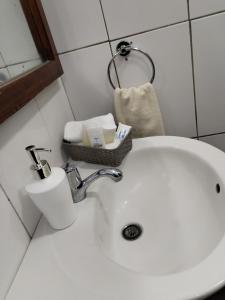 a bathroom sink with a basket of toiletries on it at Galápagos Apartment in Puerto Ayora