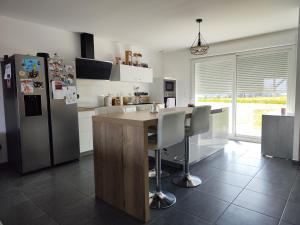 una cucina con frigorifero e tavolo con sedie di Maison avec piscine a Troche