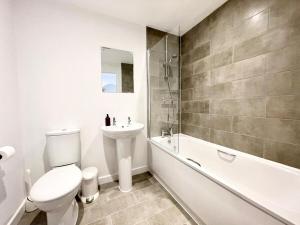 a bathroom with a toilet and a sink and a bath tub at NEW Bungalow - near Quays - Ample Free Parking - Wi-Fi in Gloucester +28 photos