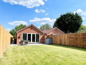 a house with a fence and a yard at NEW Bungalow - near Quays - Ample Free Parking - Wi-Fi in Gloucester