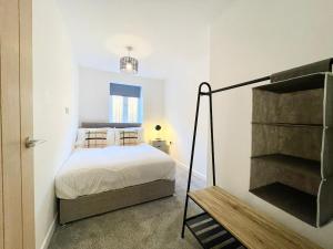 a small bedroom with a bed and a staircase at NEW Bungalow - near Quays - Ample Free Parking - Wi-Fi in Gloucester