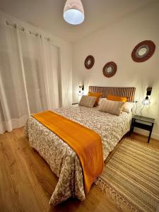a bedroom with a large bed with an orange blanket at Roma Bella in El Burgo de Osma