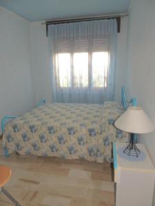 a bedroom with a bed and a lamp and a window at Appartamento Mariolu 3 in Santa Maria Navarrese