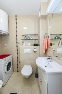 a bathroom with a toilet sink and a washing machine at Val in Kaštela
