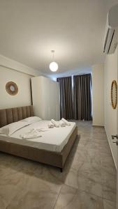 a bedroom with a large bed in a room at Gray Mirage Apartment near the beach in Orikum +5 photos