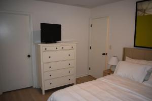 カンザスシティにあるCozy 3BR-3BA Home Near Zona Rosa Shopping and Diningのベッドルーム(ベッド1台、ドレッサー内のテレビ付)
