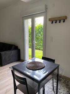 a table in a living room with a glass table at Charming studio between lakes and mountains in La Biolle