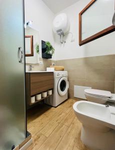 a bathroom with a washing machine and a washer and dryer at Your Exclusive Apartment near Santa Teresa Gallura in Porto Pozzo